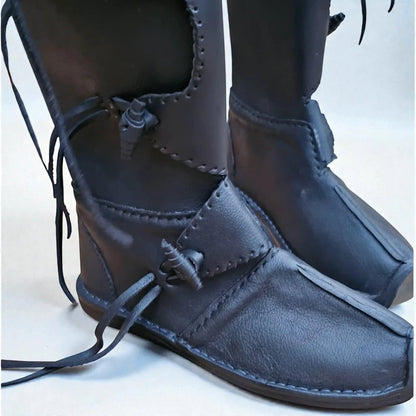 Handmade black medieval leather boots with wrap laces, detailed stitching, and full-grain texture for LARP or SCA reenactment.