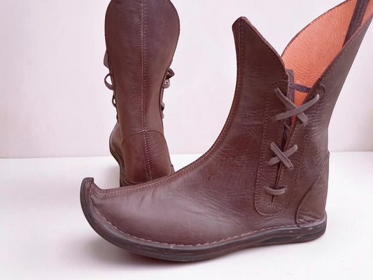 Handmade brown medieval leather boots with wrap laces, visible stitching, and full-grain leather texture, ideal for LARP or Renaissance faire.