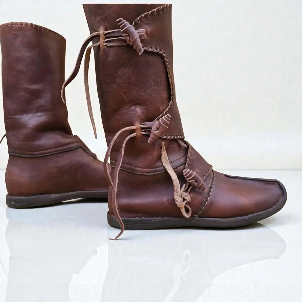 Handmade medieval leather boots with wrap laces and visible stitching, crafted from full-grain leather for LARP and reenactment.