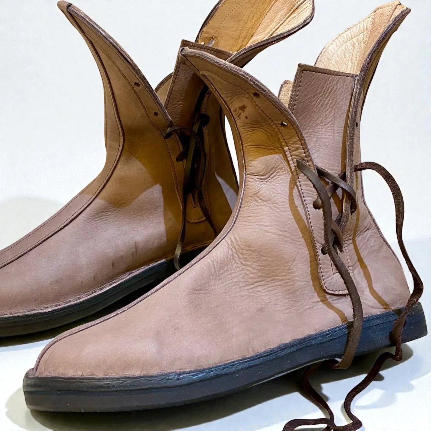 Handmade medieval leather boots with wrap laces, full-grain texture, and sturdy soles for LARP or SCA reenactment.